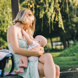 Beautiful mother breastfeeding baby. Young woman breast feeding her newborn baby.